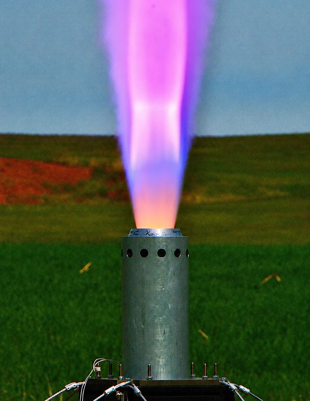 A bright purple and white exhaust plume during a static motor firing