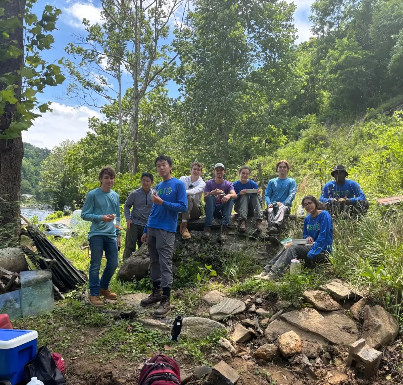 The crew sitting together on a rock wall at a work site