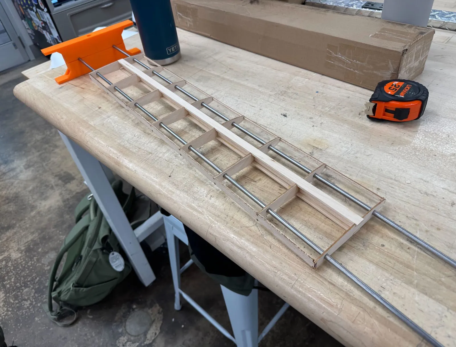 A long wing frame clamped on a workbench